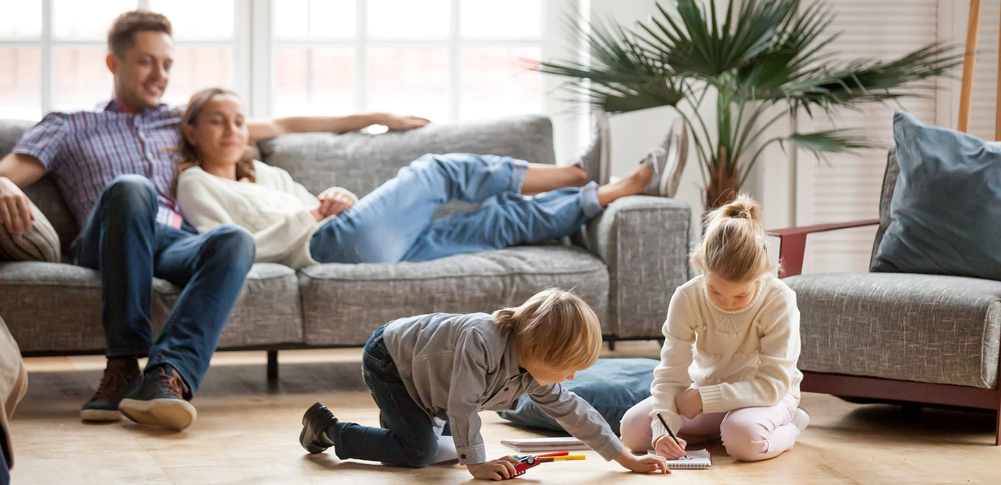 a family relaxing in living room after their hvac service is completed by an ac repairman