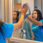 Professional cleaning service washing mirror in Denver home