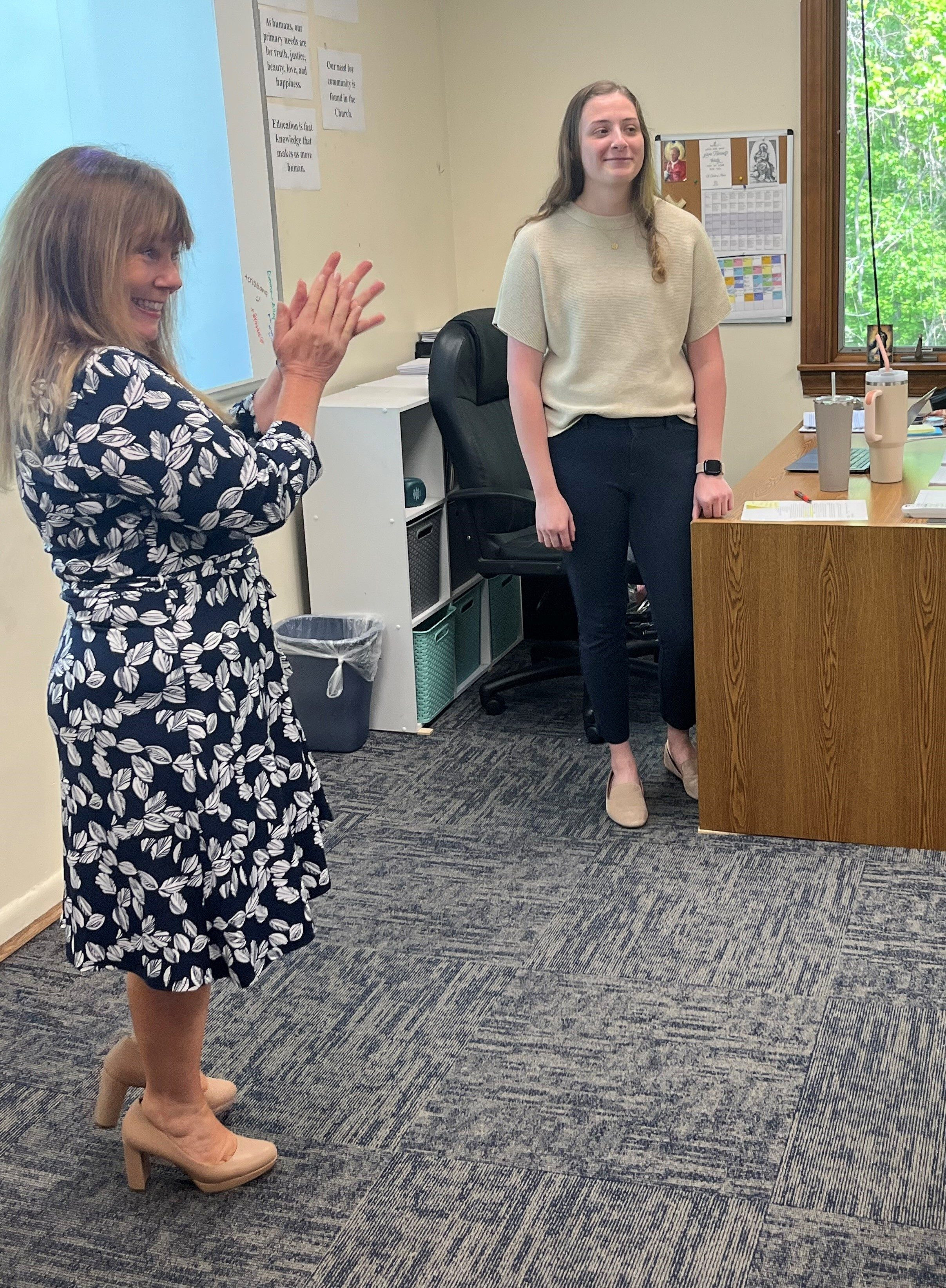 Applause for Holly Kaufmann, assistant superintendent for school operations and student services in the Catholic Schools Office of The Roman Catholic Archdiocese of Washington, applauds during a surprise visit to the ninth grade religion class of Holly Kaufmann, at right, of St. Mary’s Ryken High School in Leonardtown, when it was announced that Kaufmann is a 2024 Golden Apple Award-winning teacher.