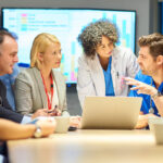 Business and medical professionals talking around a conference table