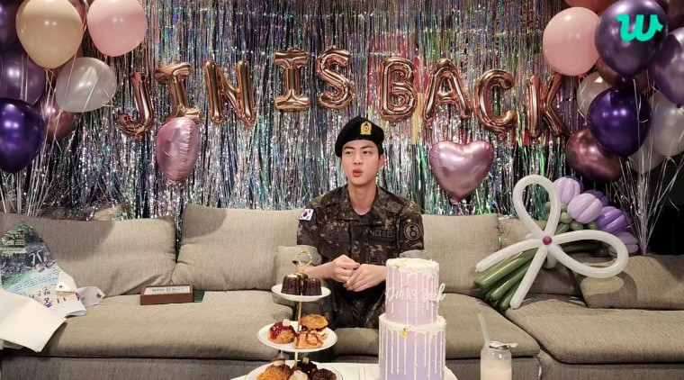 Jin waving to fans during a live broadcast after his military discharge in June 2024