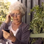 Woman looking concerned at her phone, representing potential victims of social security scams