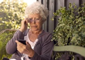 Woman looking concerned at her phone, representing potential victims of social security scams