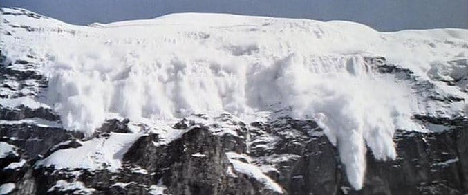 Avalanche triggered by explosives during the filming of On Her Majesty's Secret Service, showcasing the scale and controlled chaos of the practical effects used to create realistic and impactful action sequences.