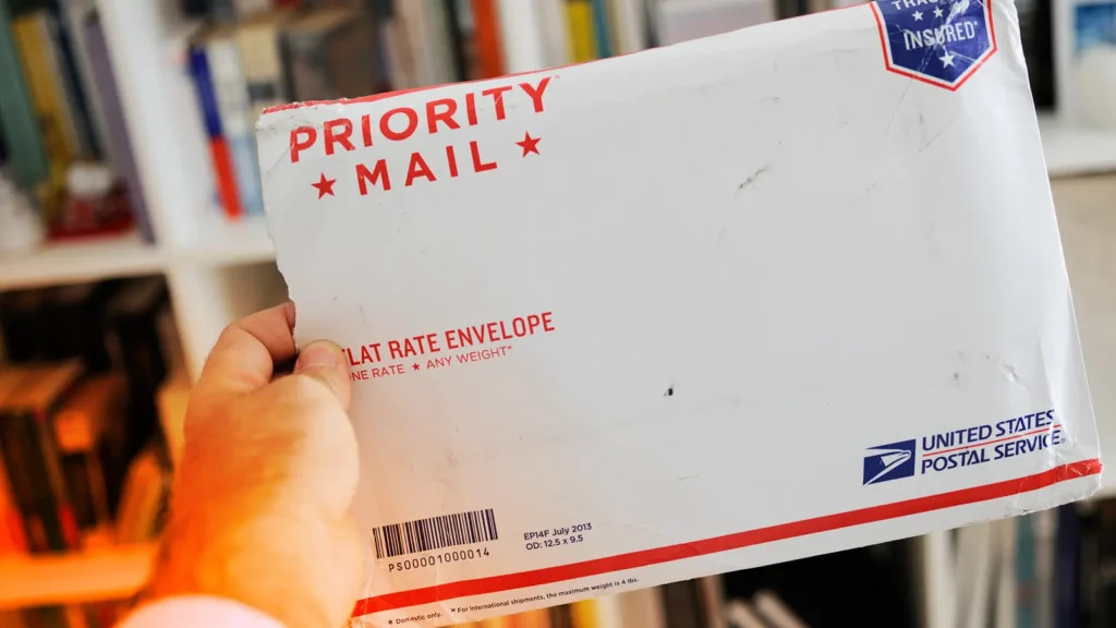 Close-up of a USPS delivery truck with the text "Sunday Delivery Services" highlighting Priority Mail Express and Amazon Packages