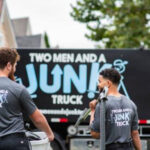 Junk specialists walking toward junk removal truck