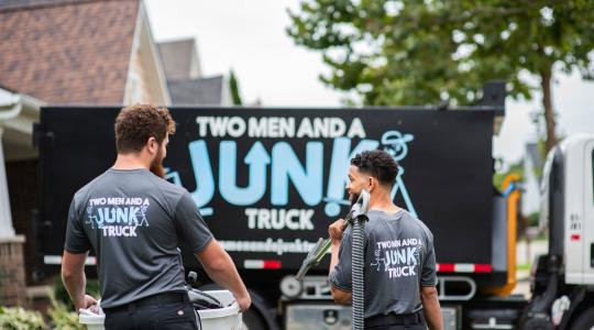 Junk specialists walking toward junk removal truck