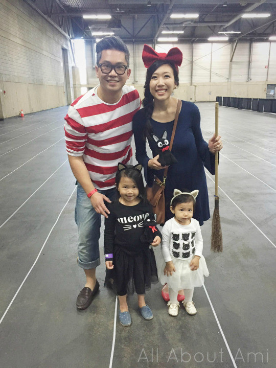 Close up of two young girls dressed as black cats from Kiki's Delivery Service, wearing cat ears and tutus, smiling and enjoying the cosplay.