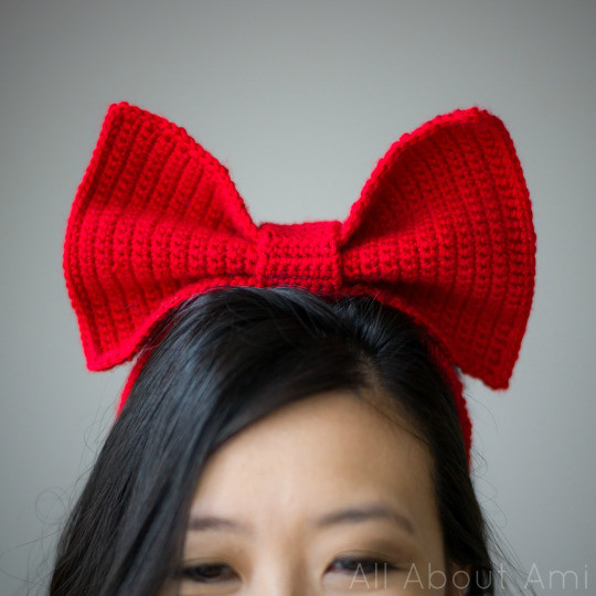 Cosplayer wearing the finished Kiki bow headband, showcasing its shape and vibrant red color as part of the Kiki costume.