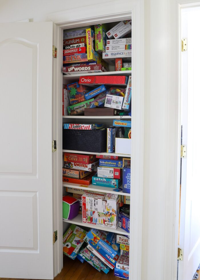 Messy game closet with stacks and stacks of disorganized board games