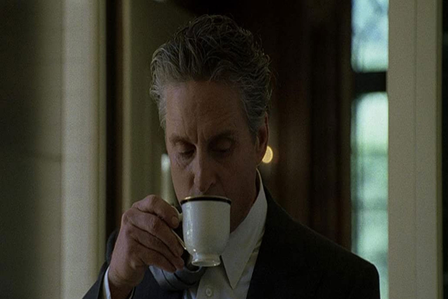 Michael douglas in The Game drinking coffee with his tie over his shoulder