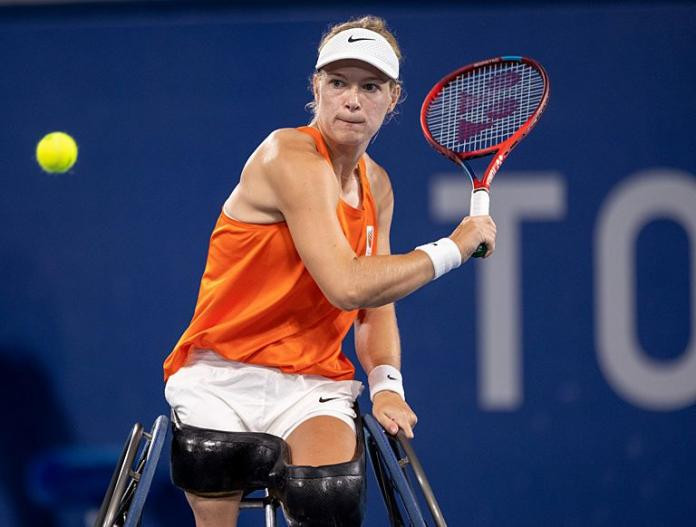 Dutch wheelchair tennis player Diede de Groot hitting a forehand during a match at the Tokyo 2020 Paralympics, showcasing her skill and focus