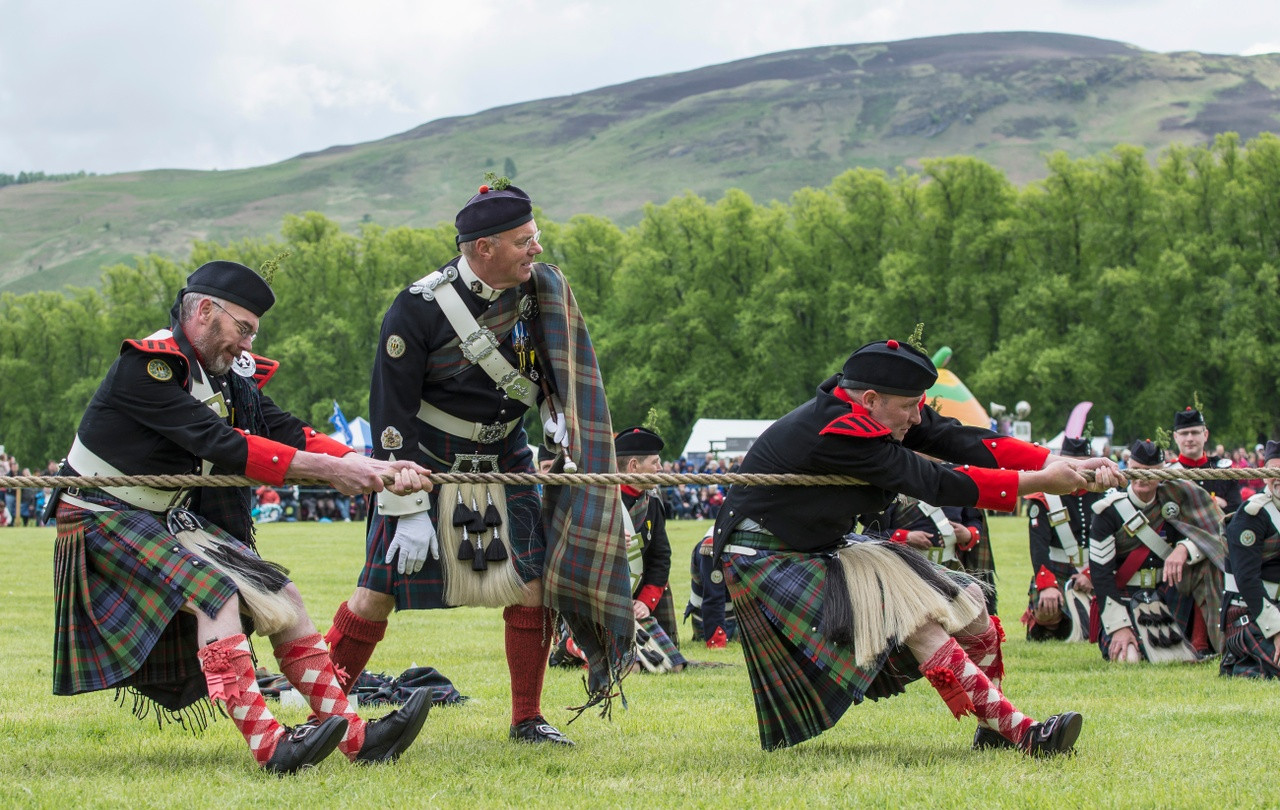 A man tossing a caber at the Highland Games, demonstrating strength and skill