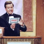 Wink Martindale looks at a card during game show, May 22, 1997.