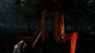 A player walking towards a person hanging from a tree in The Forest