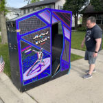 Environmental Discs of Tron arcade cabinet sitting on a street curb, awaiting pickup