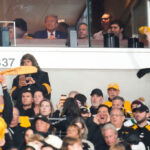 Donald Trump enjoying the Steelers game from a suite, sparking discussions about politics and sports