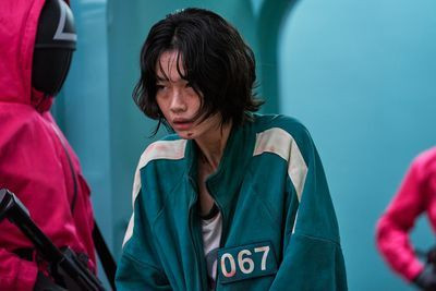 Hoyeon as Kang Sae-byeok, or player 067, facing off against a guard in pink in squid game season 1