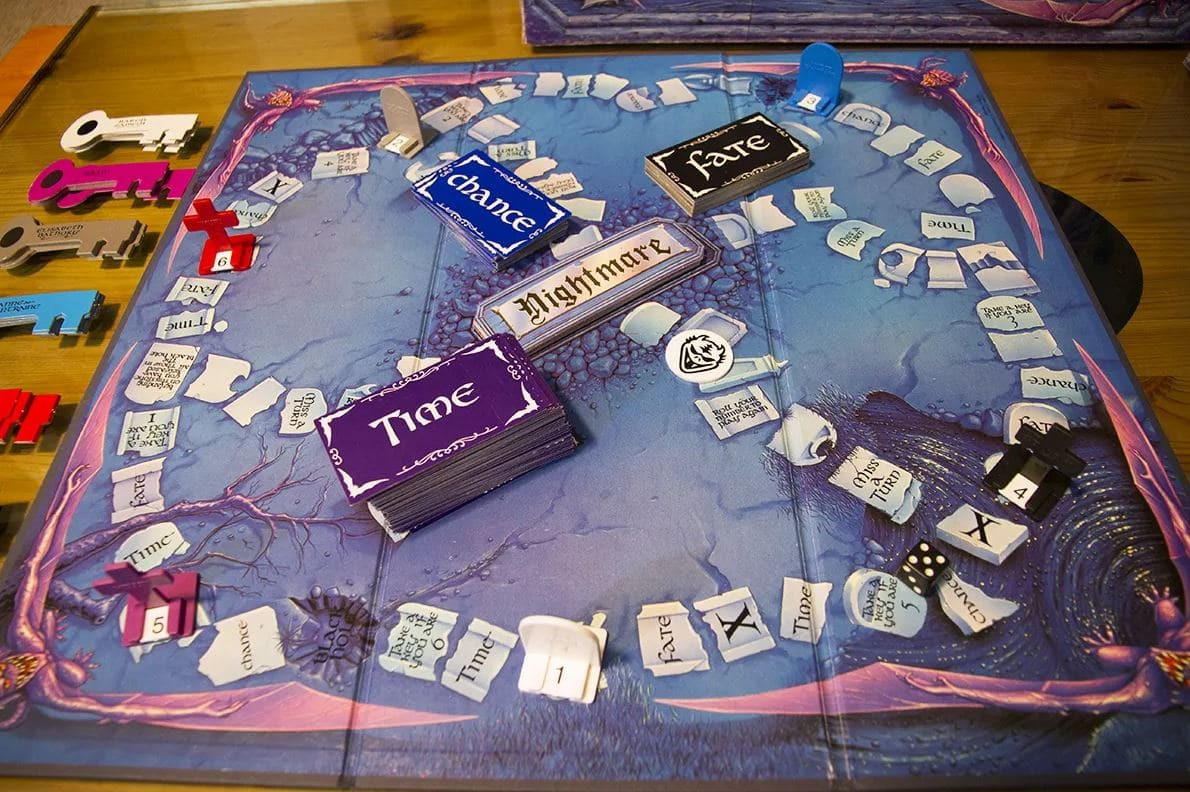 A close-up of the Atmosfear board game, featuring eerie keys and various cards like 