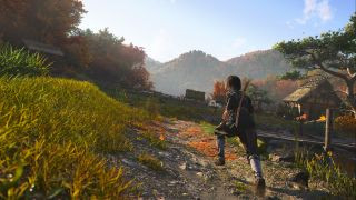 Image of Naoe walking through a grassy field outside of the Hideout