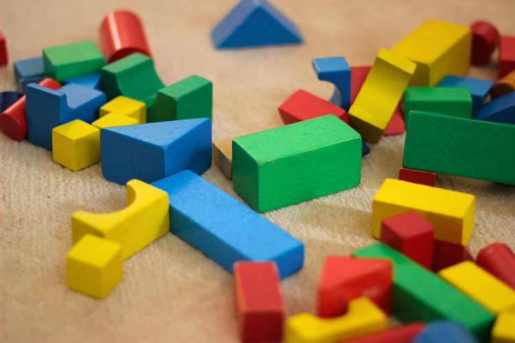 A blindfolded guest stacking baby blocks