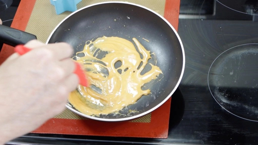 Melted Squid Game Dalgona candy in a skillet, ready for the next step.
