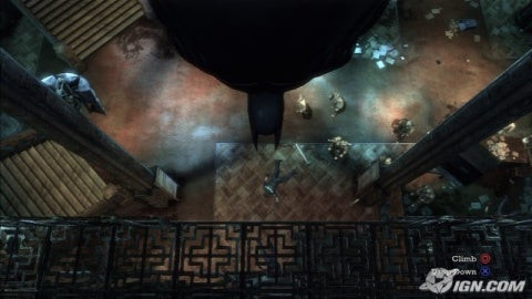 Batman gazes intensely, framed by the dark architecture of Arkham Asylum, showcasing the game's gritty atmosphere