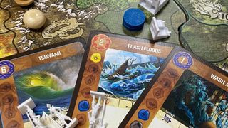 A selection of game pieces from Spirit Island, including spirit boards and invader miniatures