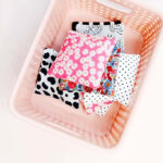 Cutting fabric squares for bean bags, showcasing colorful cotton scraps and a rotary cutter