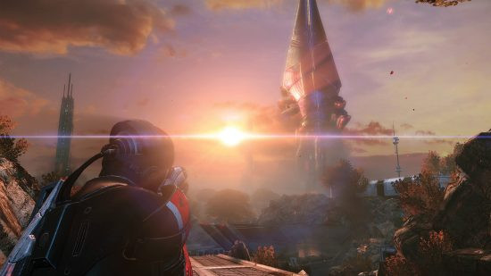 Mass Effect Legendary Edition: A character in futuristic clothes looking at the sun setting on an alien planet, showcasing the game's immersive world and compelling narrative