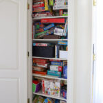 Messy game closet with stacks and stacks of disorganized board games