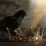 A jeweled golden crown resting on a dark surface