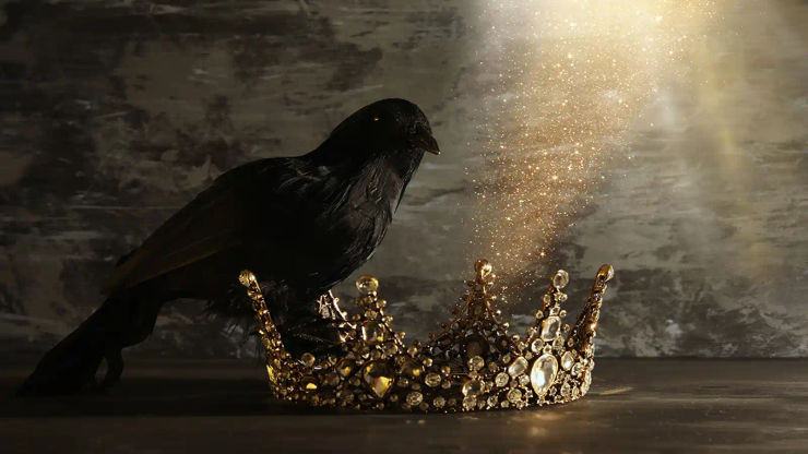 A jeweled golden crown resting on a dark surface
