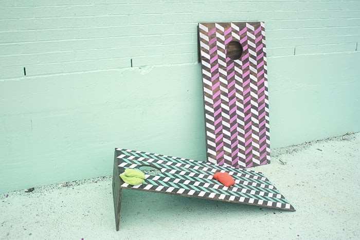 A set of homemade DIY cornhole boards are sitting against a white background. 