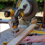 2x4 board on miter saw and being cut for giant jenga game