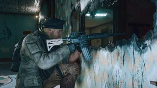 Rainbow Six Siege screenshot of a soldier aiming through a broken wall at an unseen target