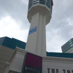 Sign listing attractions, including Galaxian 3, at the Minolta Tower in 1995