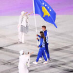 Athletes carrying the flag of Kosovo walk into the olympic arena in Tokyo