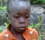 Young boy wearing an orange shirt after being found in Matusadona Game Park, Zimbabwe, highlighting the community's relief and successful rescue efforts.
