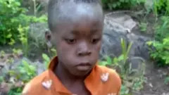 Young boy wearing an orange shirt after being found in Matusadona Game Park, Zimbabwe, highlighting the community's relief and successful rescue efforts.