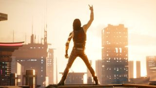Cyberpunk 2077 screenshot of Johnny Silverhand standing on a rooftop ledge holding a microphone in one hand, raising devil horns with another over Night City