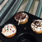 In-game: 3 decorated cupcakes in a baking pan.