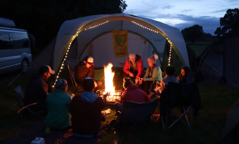 Family playing a game around the campfire