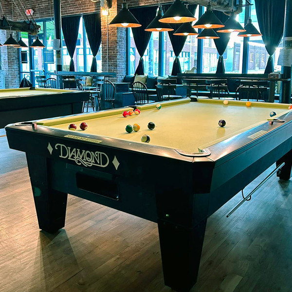 Chartreuse Saloon alt: Inside the Chartreuse Saloon, the eclectic game room and saloon atmosphere invites patrons to indulge in a choose-your-own-adventure nacho platter while engaging in games like steel-tip darts and pool.