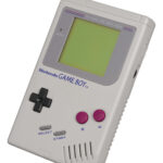 A classic Nintendo Game Boy console displaying Tetris.
