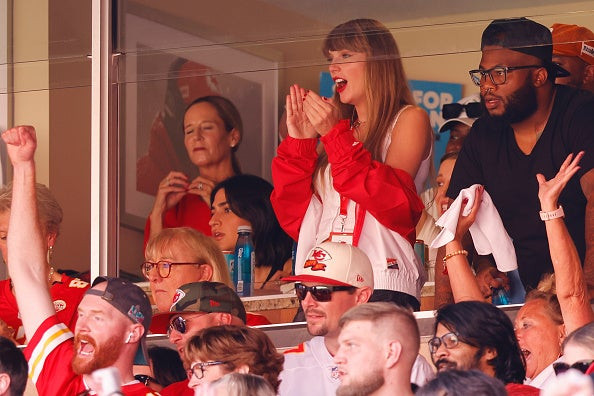 Taylor Swift during the Bears game, wearing a Chiefs jacket and black denim shorts.
