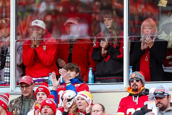 Taylor Swift reacting during the Bills game, wearing Chiefs logoed gear.