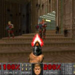Screenshot from the video game Doom. A retro first person shooter game where you blast demons. A gun is being fired at humanoid enemies that are coming down a staircase.