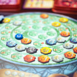 The board game The Quacks of Quedlinburg on a table. The player board, shaped like a cauldron, features many pieces placed in a spiral on the board.