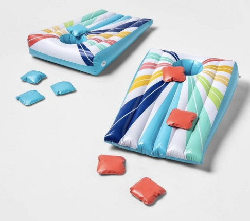 An inflatable cornhole set in pastel colors includes pink and blue bean bags. 
